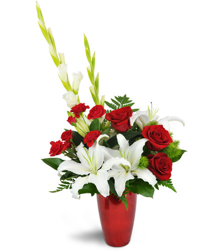 Cupid's Kiss™. An arrangement by Avenue Flowers and Gifts. Red roses are elegantly accompanied by pretty white lilies and accented with fresh...