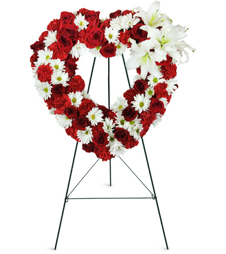 Rosy Remembrance Heart Wreath™. An arrangement by Avenue Flowers and Gifts. Red roses, white lilies, white daisies, and red carnations are...