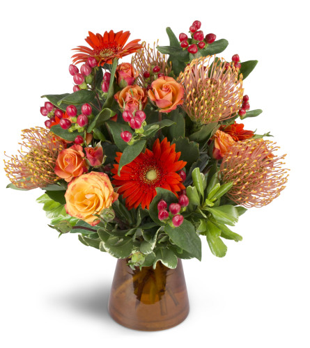 Energetic Orange™ - Deluxe. An arrangement by Avenue Flowers and Gifts. Unique pincushion protea are arranged with orange spray roses, mini...