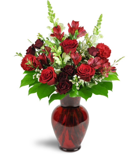 Rosy Rapture™ - Deluxe. An arrangement by Avenue Flowers and Gifts. Red roses, spray roses, and alstroemeria are arranged with white snapdragons...