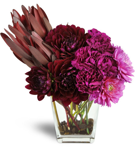 Modern Romance™. An arrangement by Avenue Flowers and Gifts. Dahlias, carnations, and leucadendron are arranged in a glass vase with river rocks..